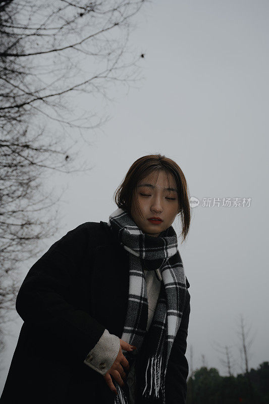 Asian girl walking by the river in rainy weather